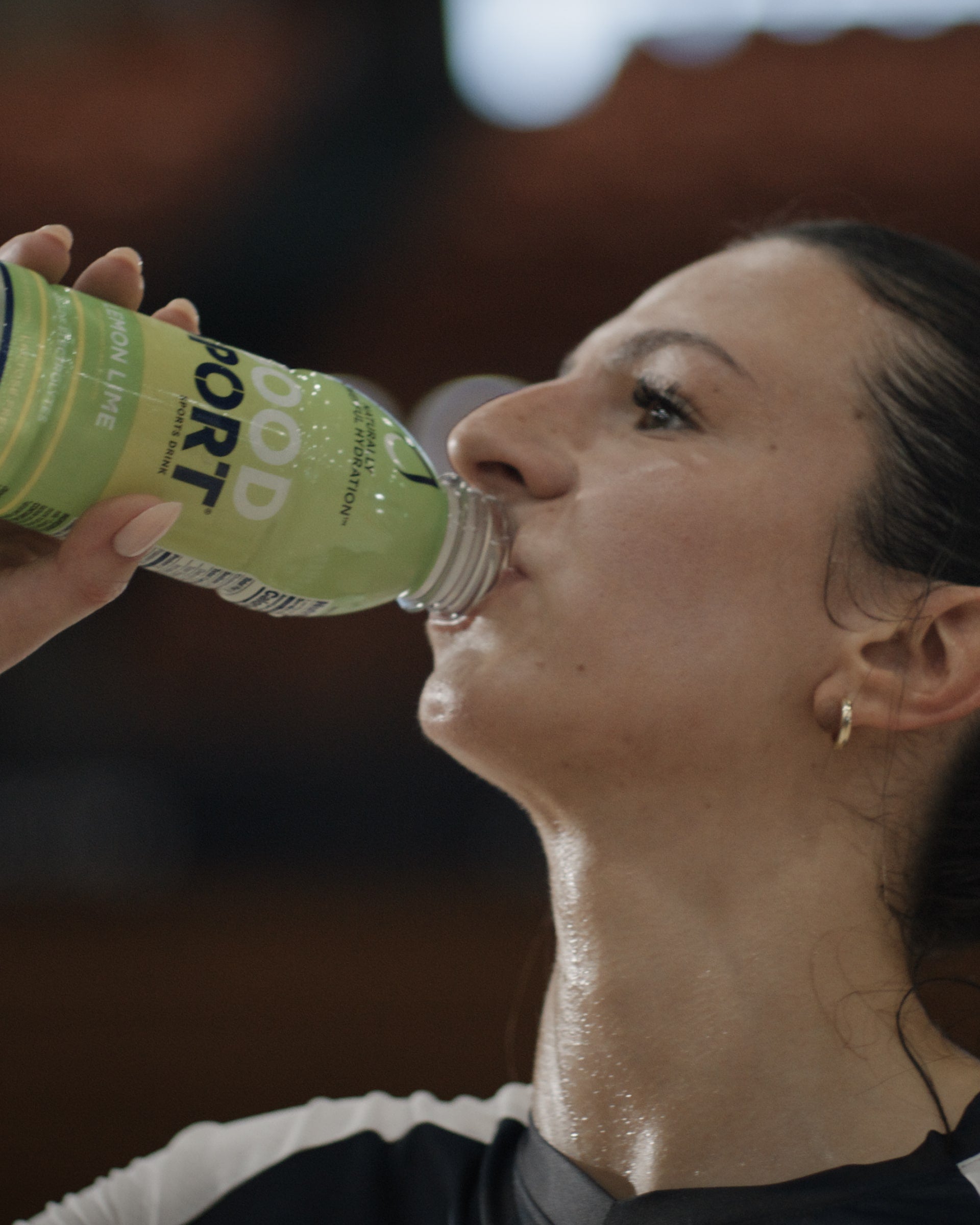Volleyball player drinking Lemon Lime GoodSport after an intense game.