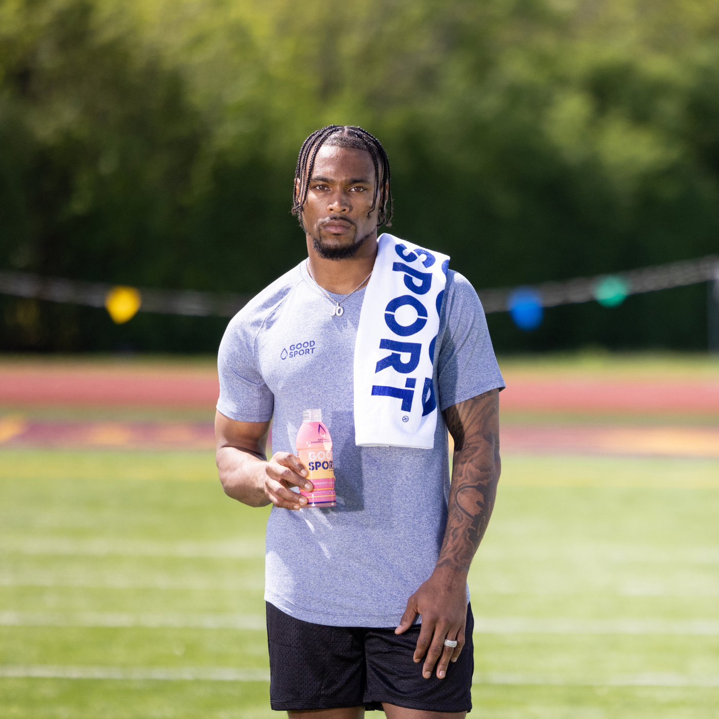 Professional athlete, Jonathan Owens, standing on football field holding GoodSport.