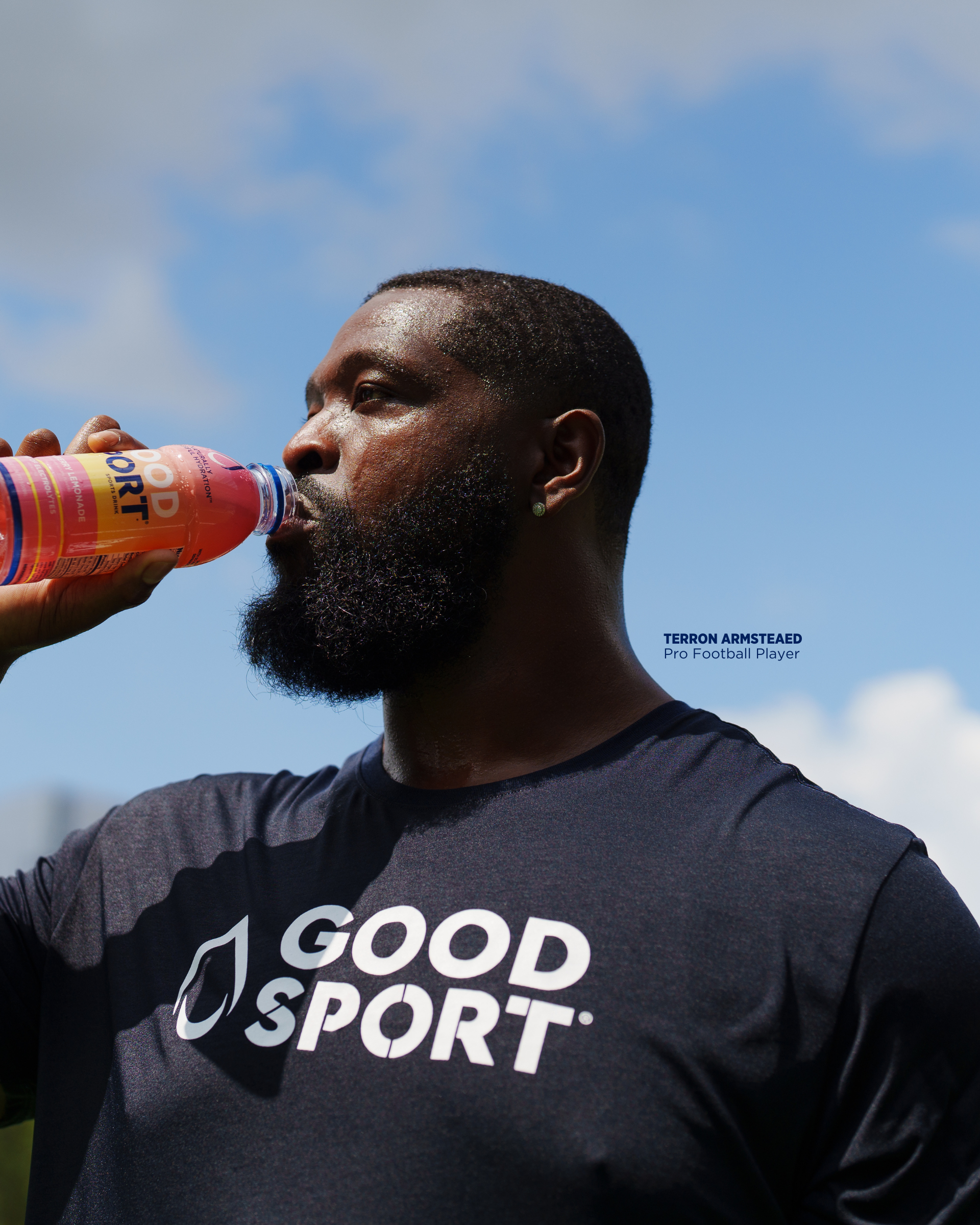 Pro football player Terron Armstead drinking a bottle of Strawberry Lemonade GoodSport sports drinking after training.