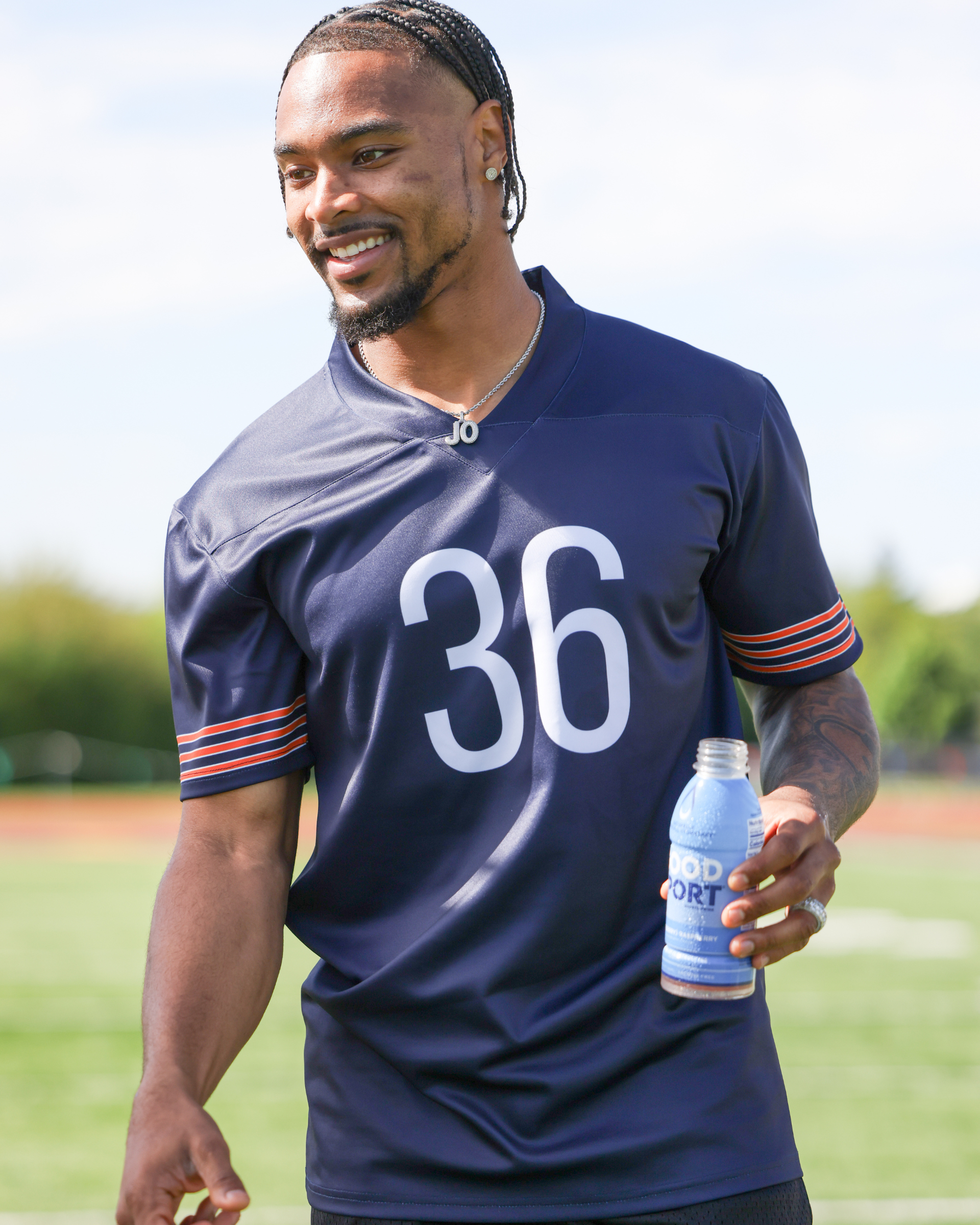 Pro Football Player Jonathan Owens holding a bottle of GoodSport