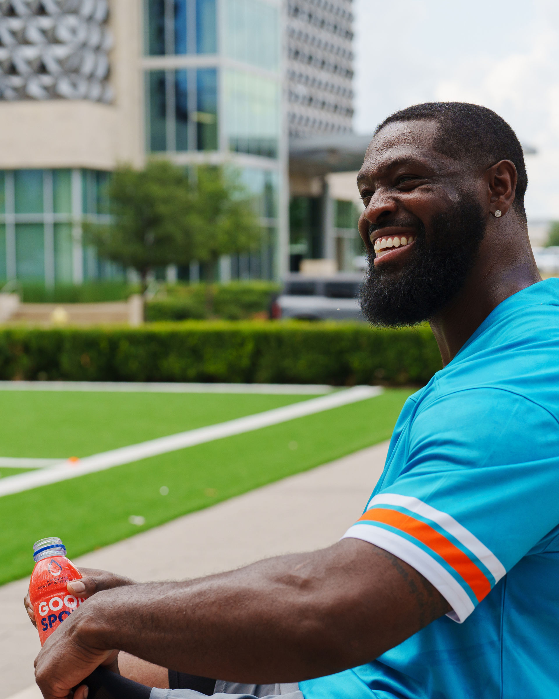 Pro Football Player Terron Armstead holding a bottle of GoodSport