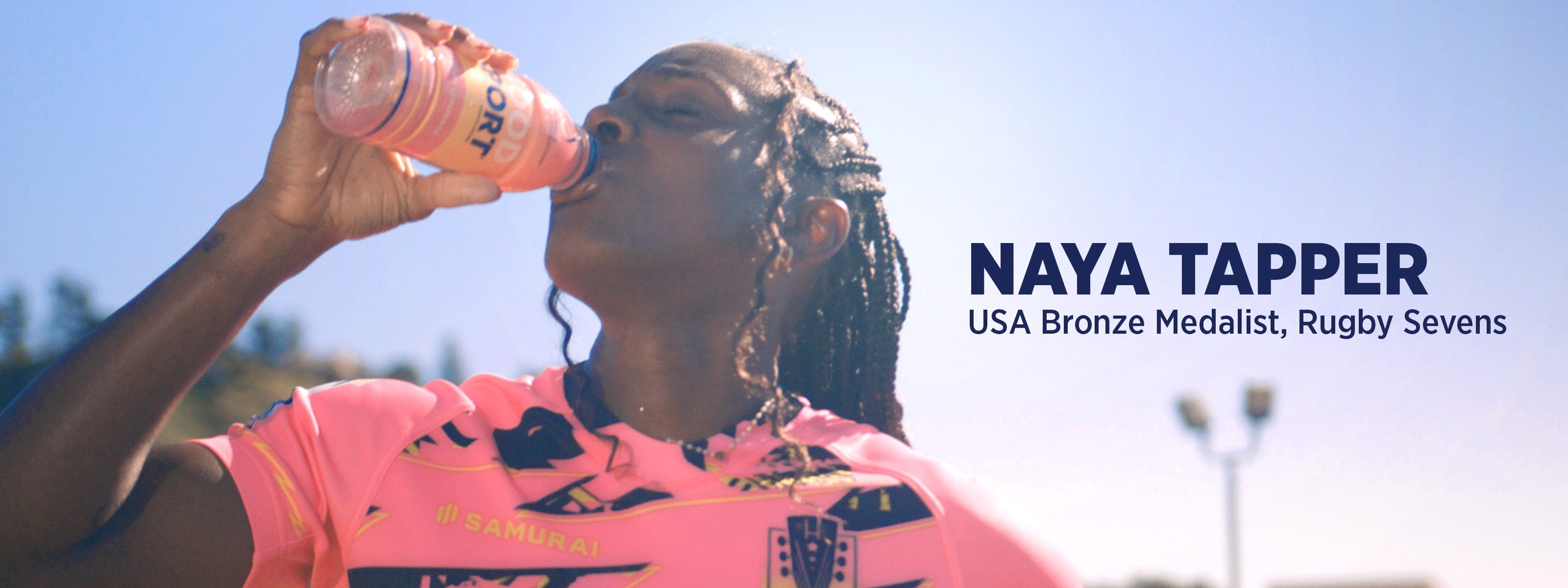 Professional athlete drinking Strawberry Lemonade GoodSport on sunny day. Naya Tapper, USA Bronze Medalist, Rugby Sevens. 