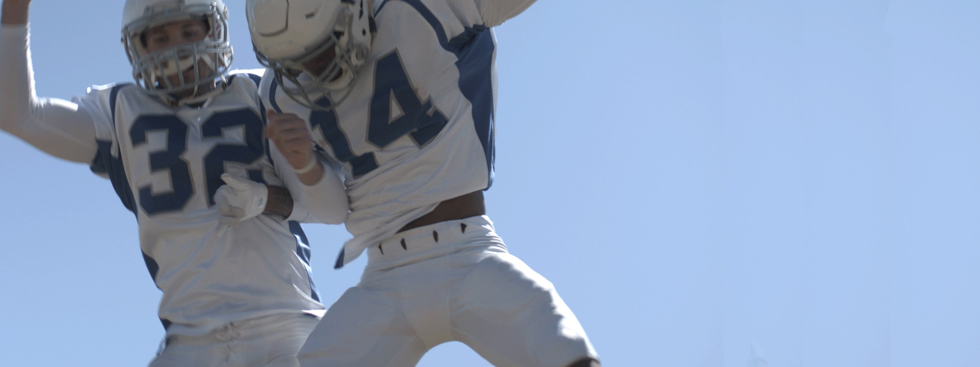 Football athletes jumping in celebration. 