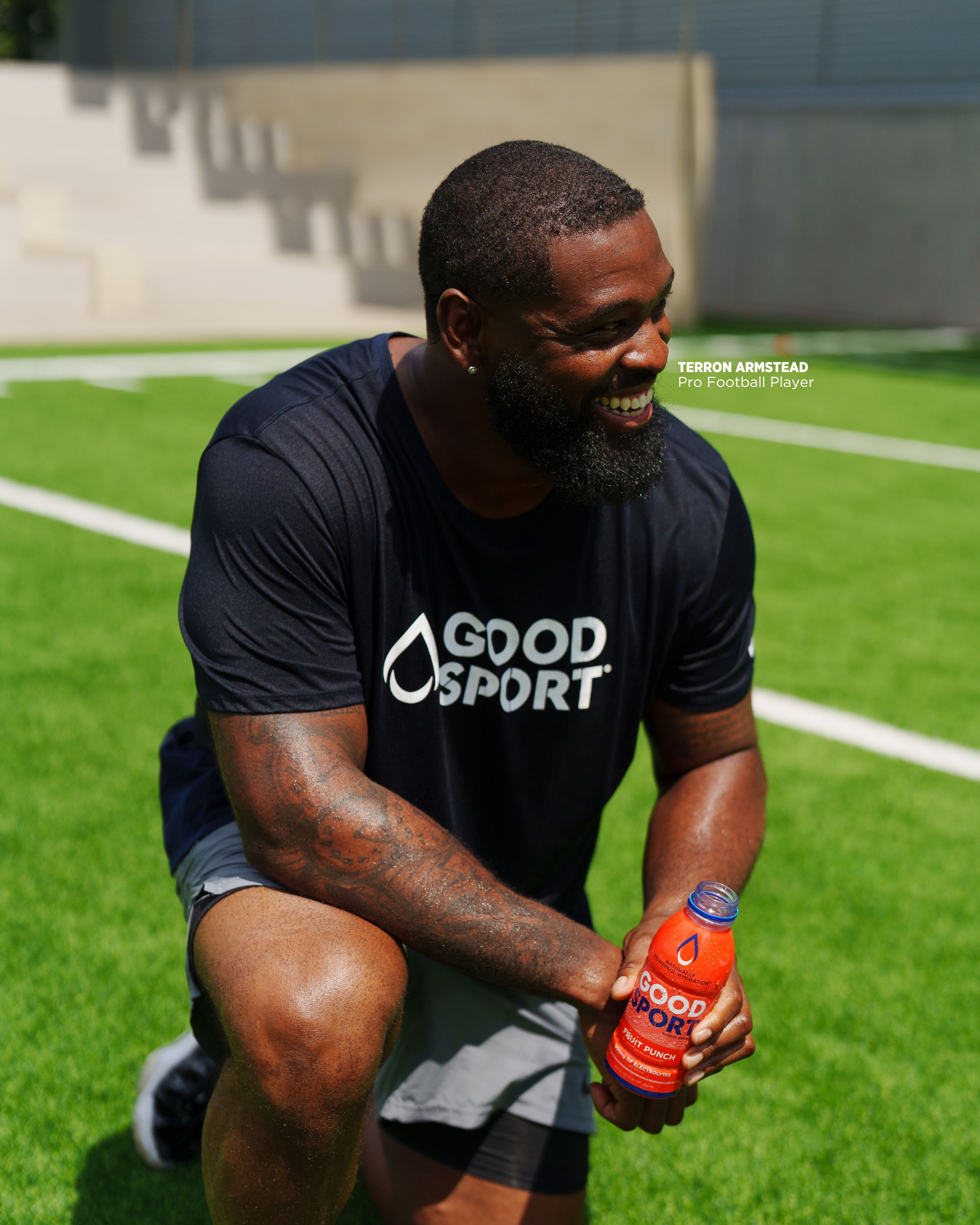 Pro football player Terron Armstead drinking a bottle of GoodSport on practice field
